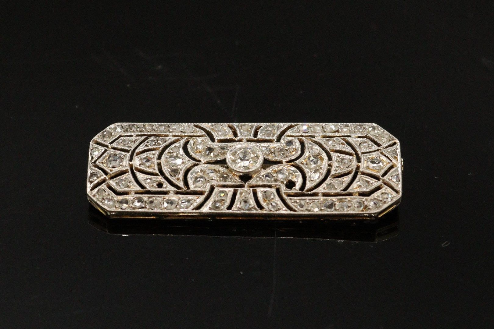 Null 一枚18K（750）黄金和铂金矩形胸针，中央有一颗老式切割钻石（约0.18克拉），在镂空镶嵌的亮片（缺两颗）中。



毛重：7.80 g - 11 &hellip;