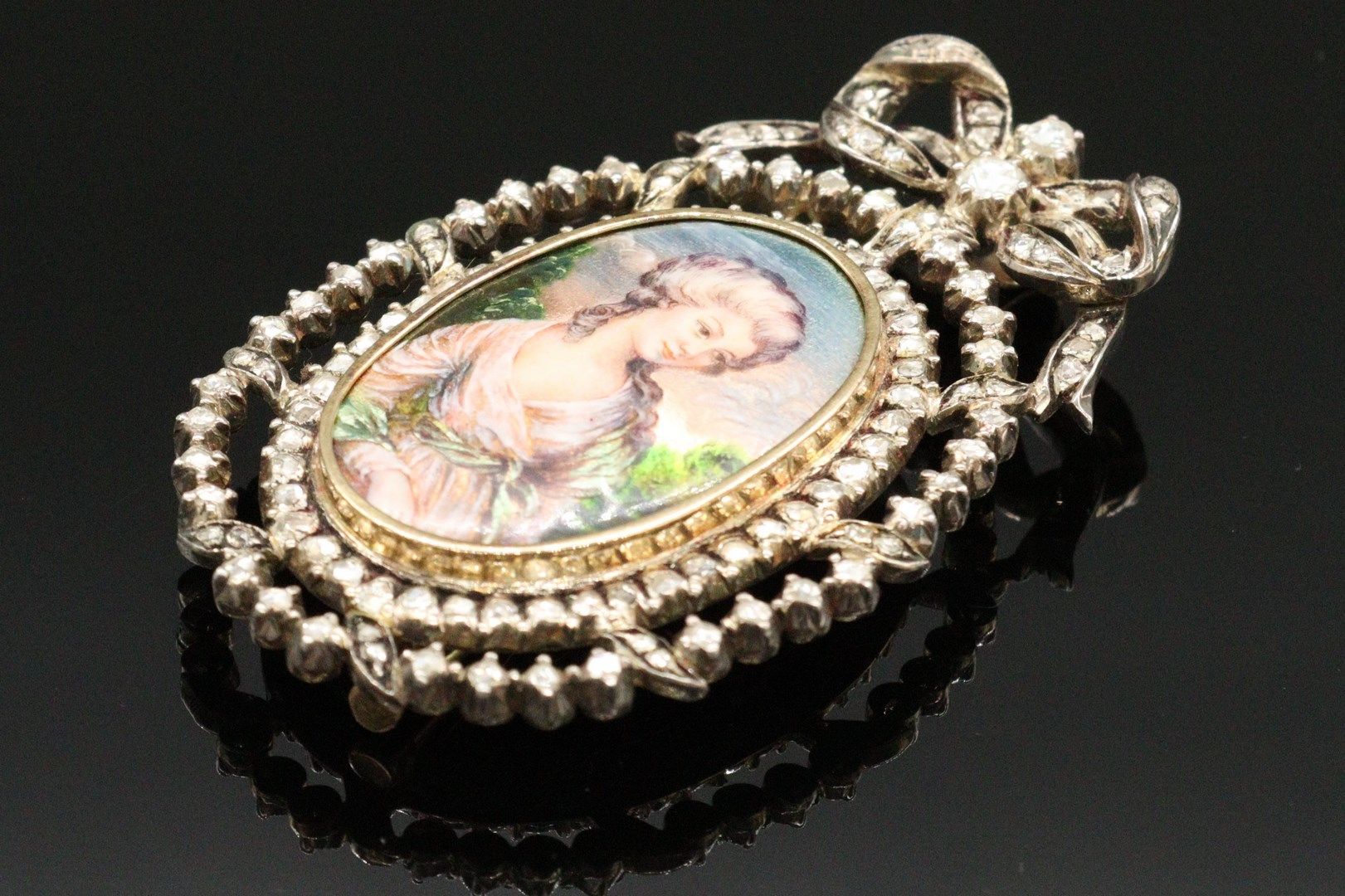 Null 一枚18K (750)金胸针挂件，上面有一个多色珐琅的18世纪服饰的年轻女子的缩影，上面有一个蝴蝶结，全部镶嵌着玫瑰切割钻石。

20世纪的作品。

&hellip;