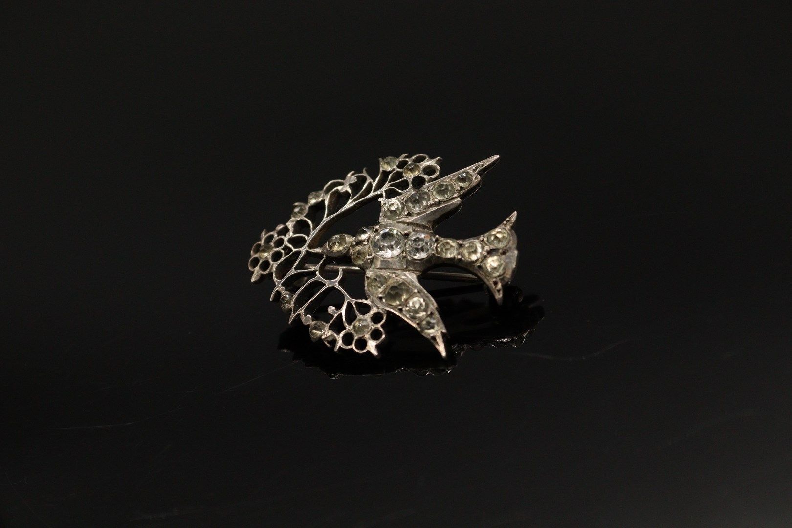 Null 一枚银质（800）"诺曼底圣灵 "胸针，上面有白色水钻，一只鸽子用嘴叼着树枝。

标记：缺席。

长度：3.5厘米。

毛重：7.80克。