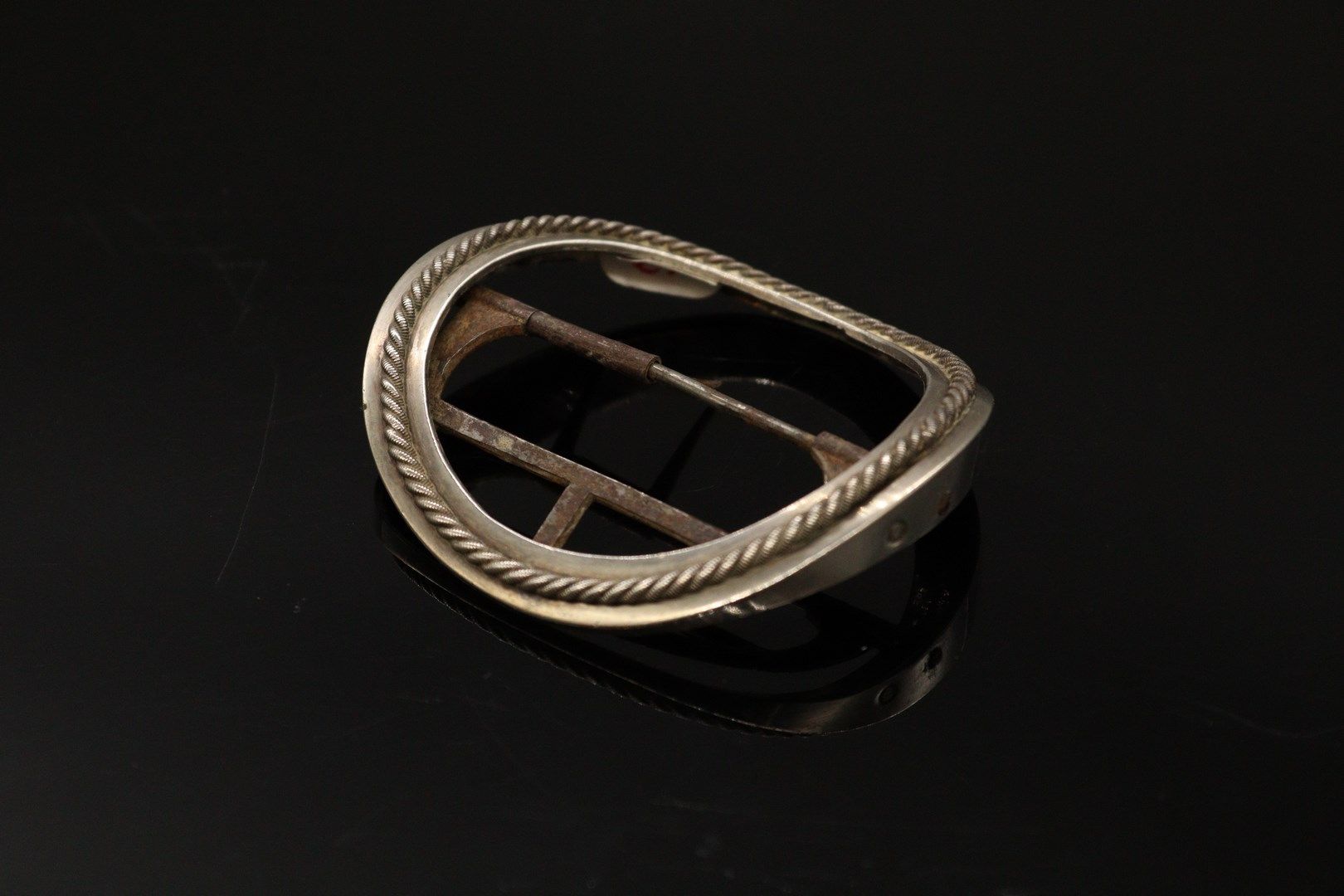 Hebilla circular de plata (950) con diseño de cordón. 
Marcas: 
- de 1º título P&hellip;
