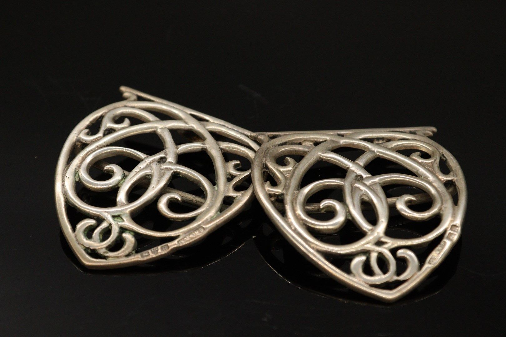 Null Clasp of coat in silver (925) formed of openwork scrolls.

Punches : 

- 1s&hellip;