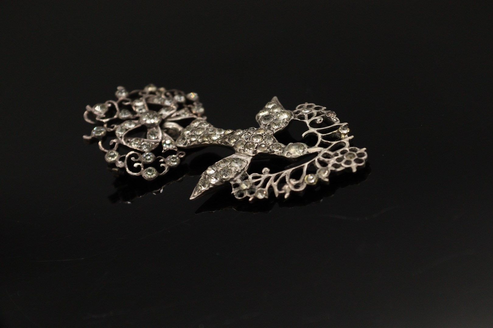 Null 一枚银质（800）"Norman Holy Spirit "胸针-吊坠，装饰有白色水钻。 它由一只鸽子组成，由一条打结的丝带牵着，嘴里叼着一根花枝。
&hellip;