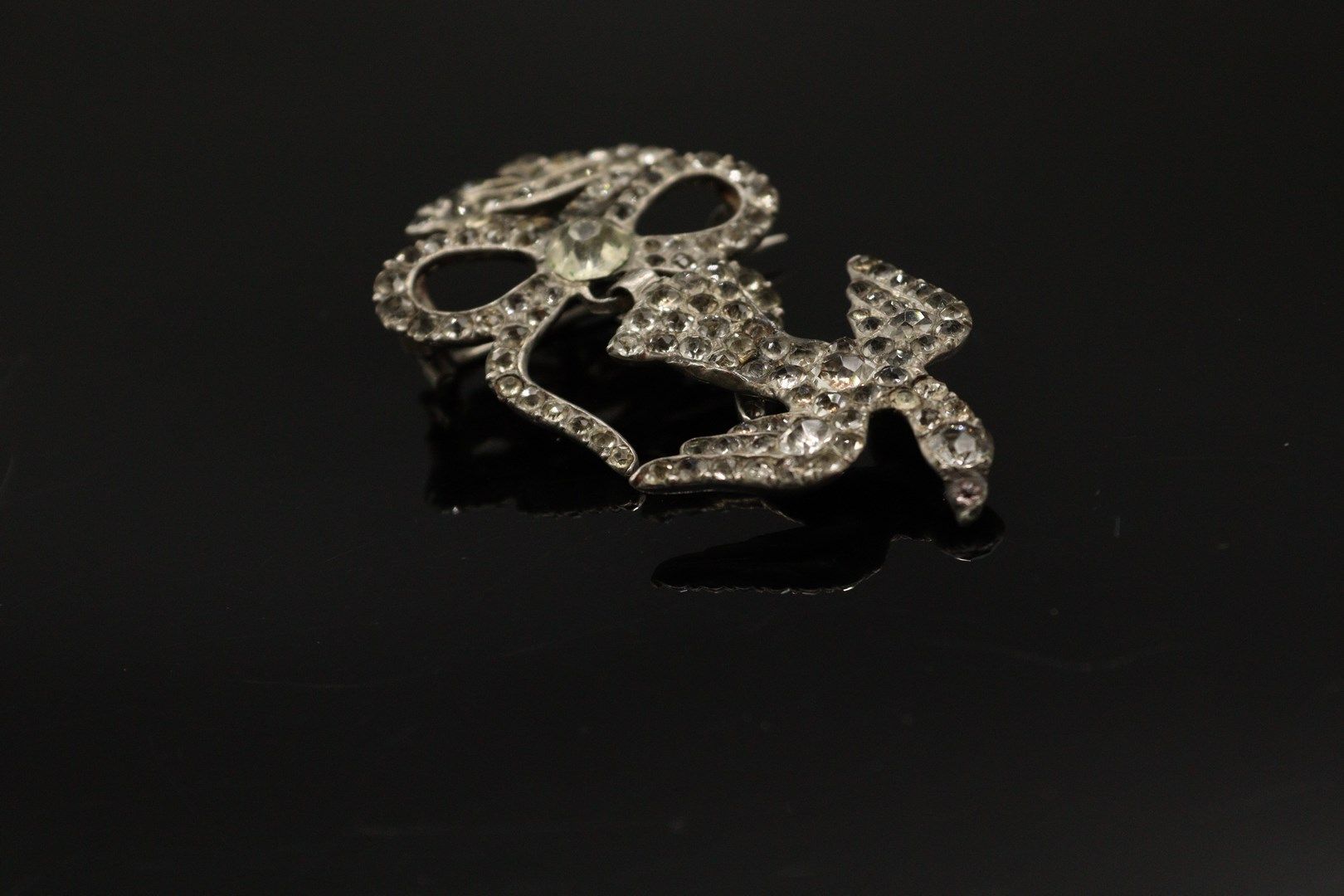 Null 银质（800）"诺曼底圣灵 "胸针，装饰有白色水钻。 胸针由一只鸽子组成，由一条打结的丝带牵着，嘴里叼着一根树枝。

以野猪为标记。

长度：4厘米。&hellip;