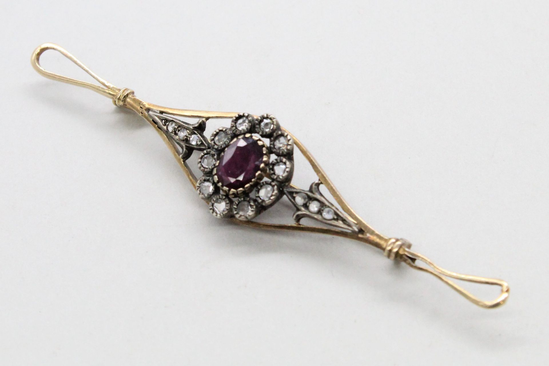 Null 镀金和镀银的金属胸针，上面有一颗钻石镶嵌的红宝石。

19世纪末，20世纪初。

毛重：10.30克。