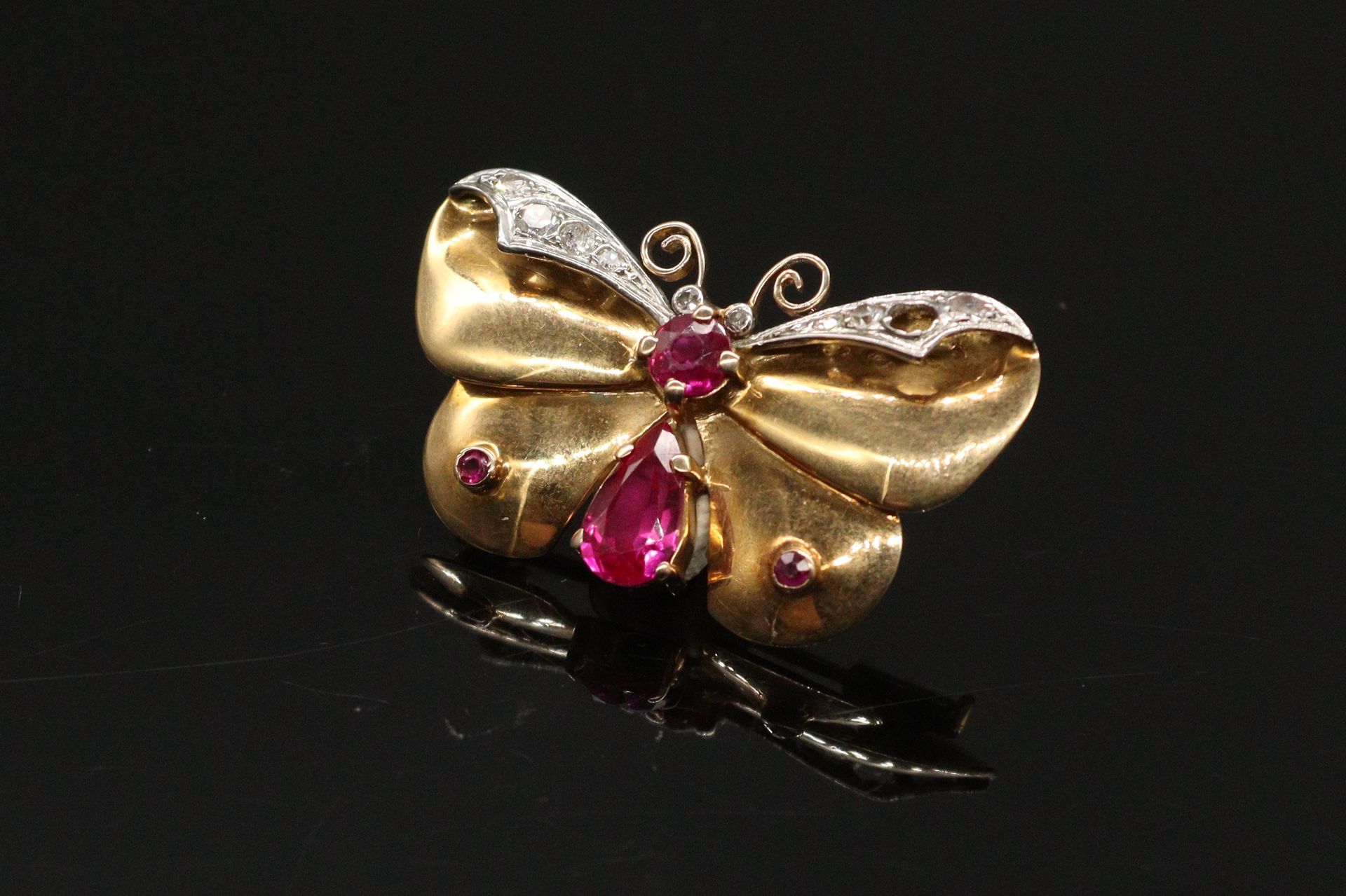 Null 18K（750）黄金和白金的蝴蝶胸针。主体镶嵌着硬石榴石，两翼镶嵌着钻石。

毛重：7.83克。

(缺失)