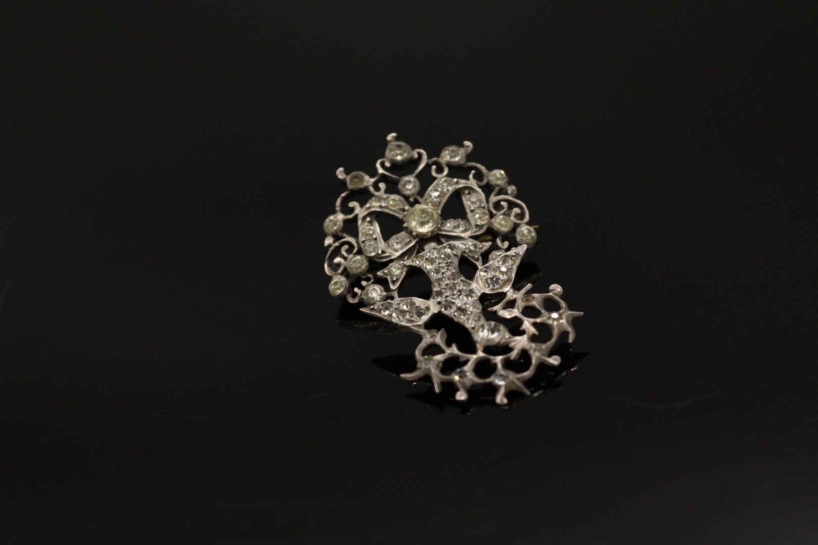 Null 一枚银质（800）"诺曼底圣灵 "胸针，装饰有白色水钻，由一只鸽子用打结的丝带固定，嘴里叼着一根树枝。

标记：缺席。

长度：5.5厘米。

毛重：&hellip;