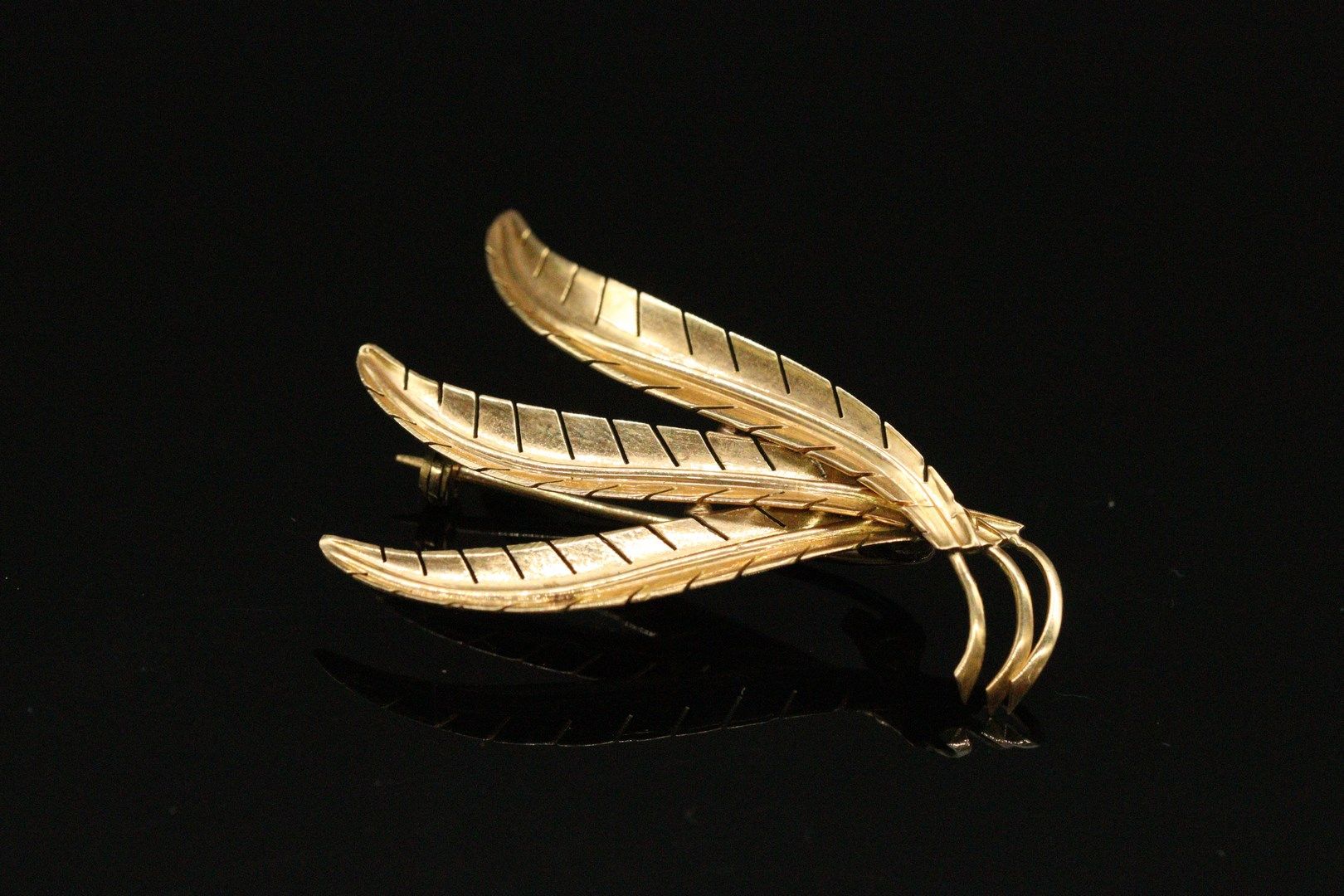 Null Brooch in 18K (750) yellow gold formed by a spray of three large palms.

Fo&hellip;