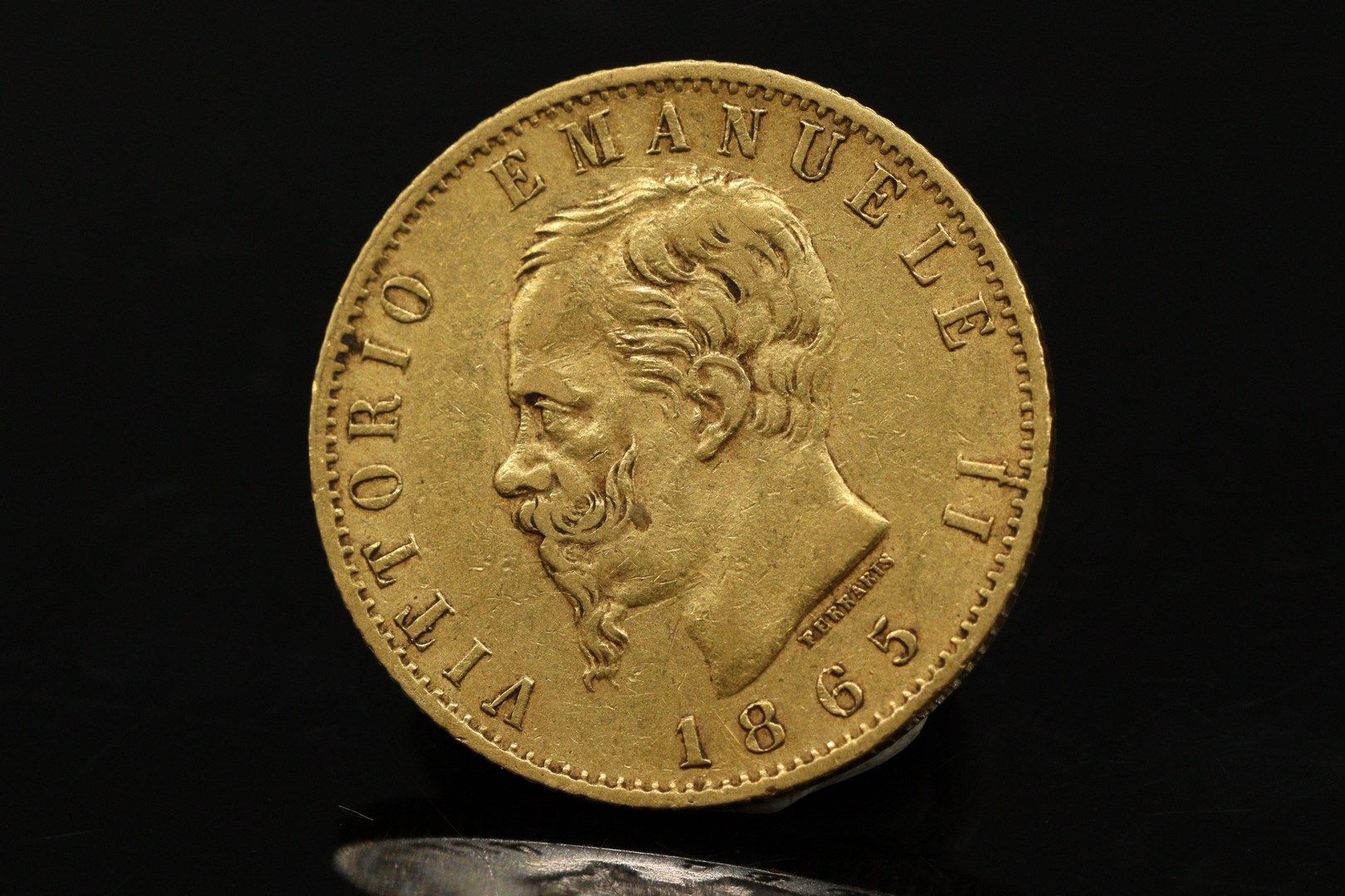 Null Gold coin of 20 lire Emanuel II (1865).

Weight : 6.43 g.