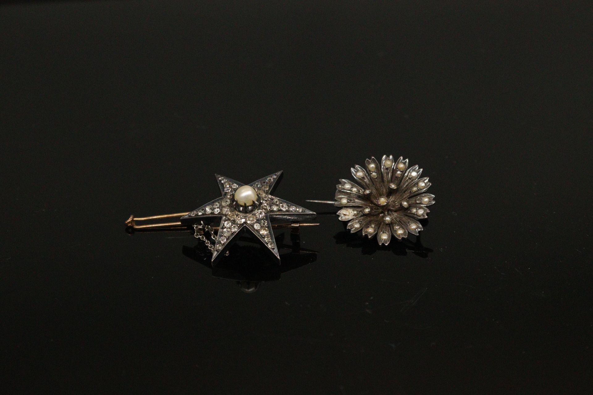 Null 镶有钻石的六芒星胸针，中间镶嵌着一颗珍珠；镶嵌在18K（750）黄金和白金中，有鹰头的印记。带安全销的安全链。

毛重：11.80克。



附有一枚&hellip;