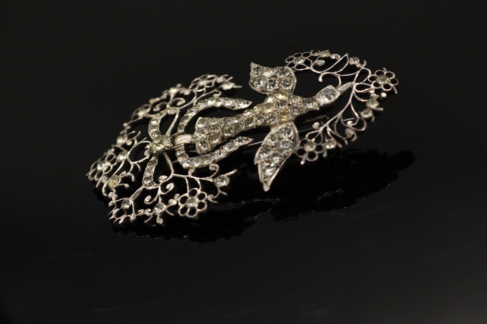 Null 银质（800）"诺曼底圣灵 "胸针，装饰有白色水钻。 胸针由一只鸽子组成，由一条打结的丝带牵着，嘴里叼着一根花枝。

标记：野猪。

长度：7厘米。
&hellip;