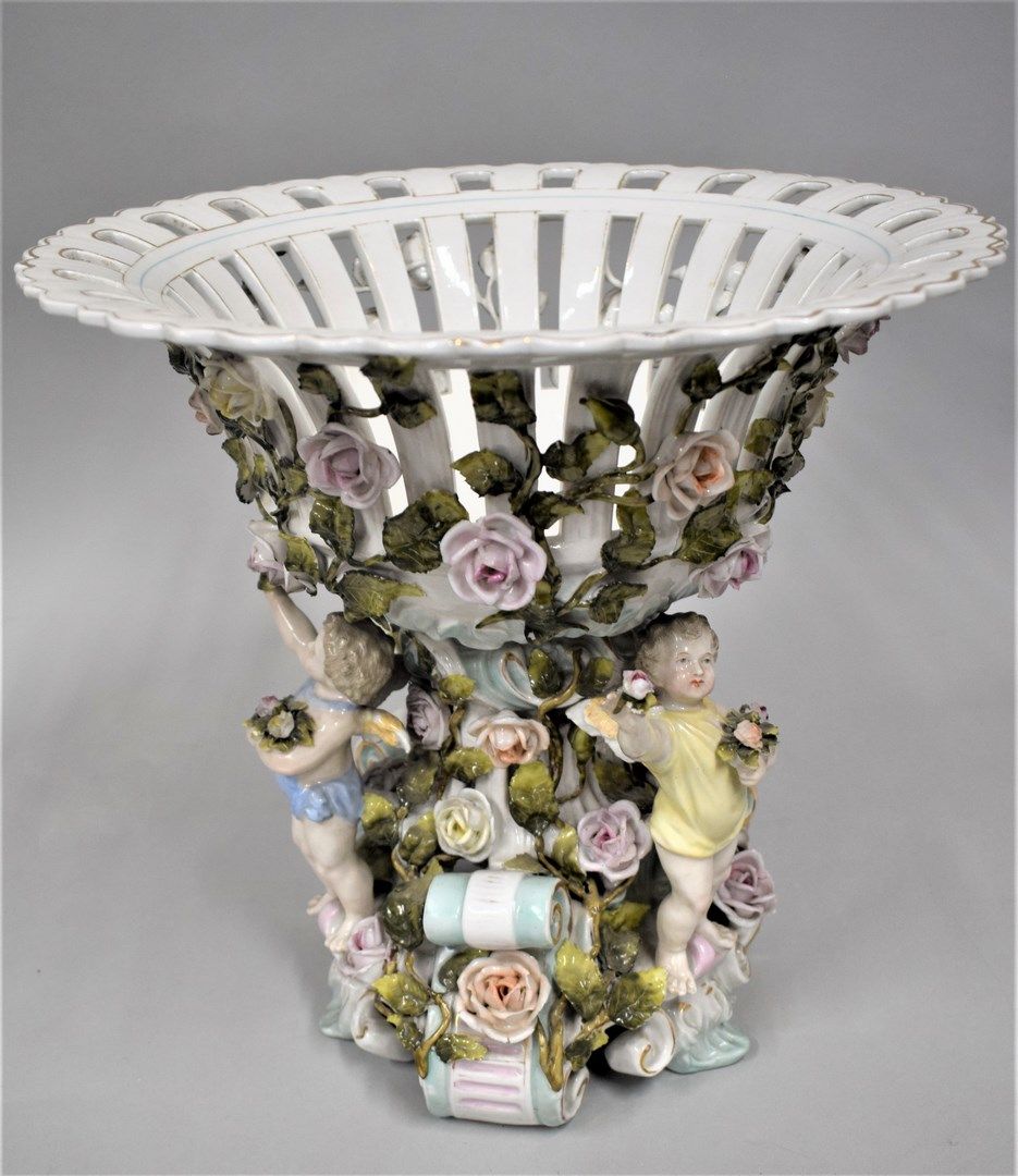 Null 德国，萨克森州，Plaue，19世纪

瓷质镂空碗放在基座上

底部和整个碗上有玫瑰和叶子的浮雕装饰。在基座上，有三个天使，拿着一束鲜花。

高：30&hellip;