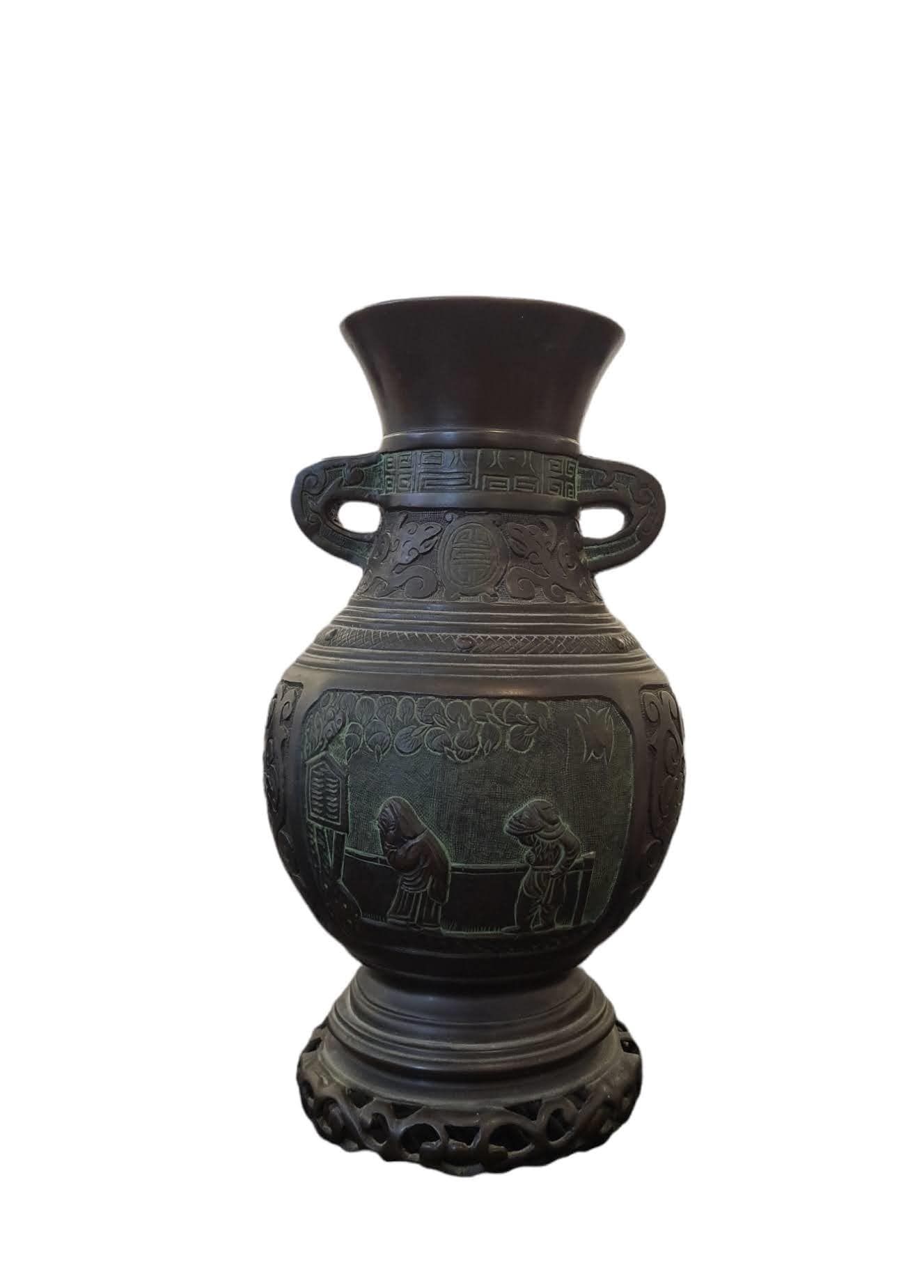 Null 日本，20世纪

一个巴里斯特尔形状的青铜花瓶，带有奖状的古色，并凿有宫廷场景的装饰。

H.30,5 cm