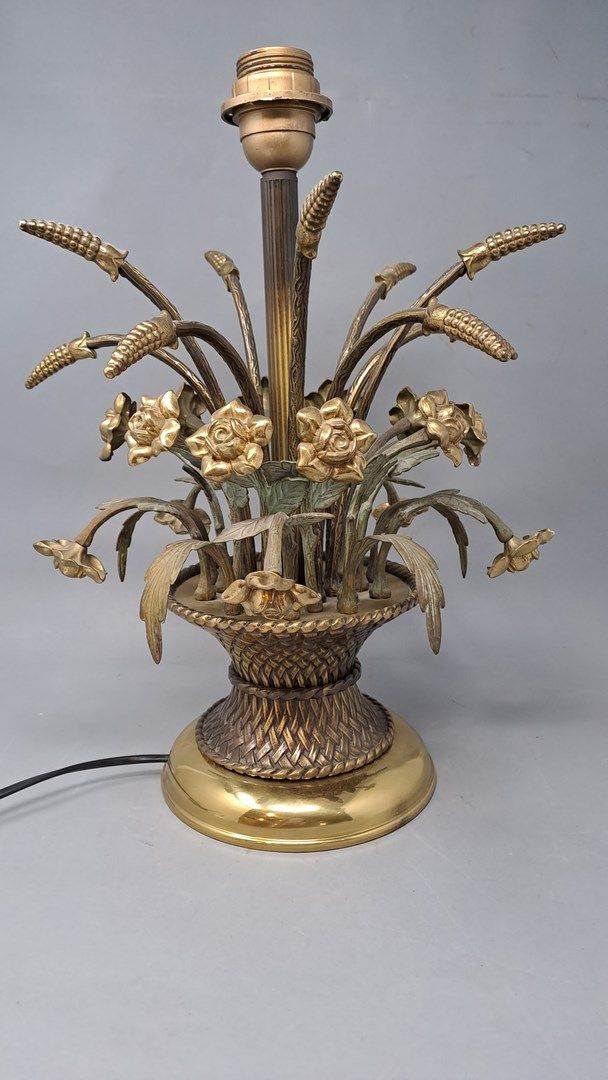 Null Un soporte de lámpara de metal dorado que estiliza un ramo de flores en un &hellip;