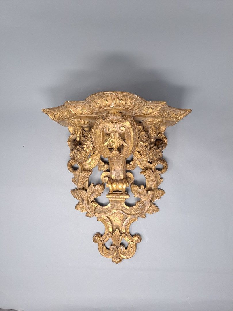 Null 一个木制和镀金的灰泥支架，上面有雕刻和模制的卷轴，刺叶和花环。

摄政风格，19世纪

H.36.6 - W. 32.8 - D. 20.1 cm

&hellip;
