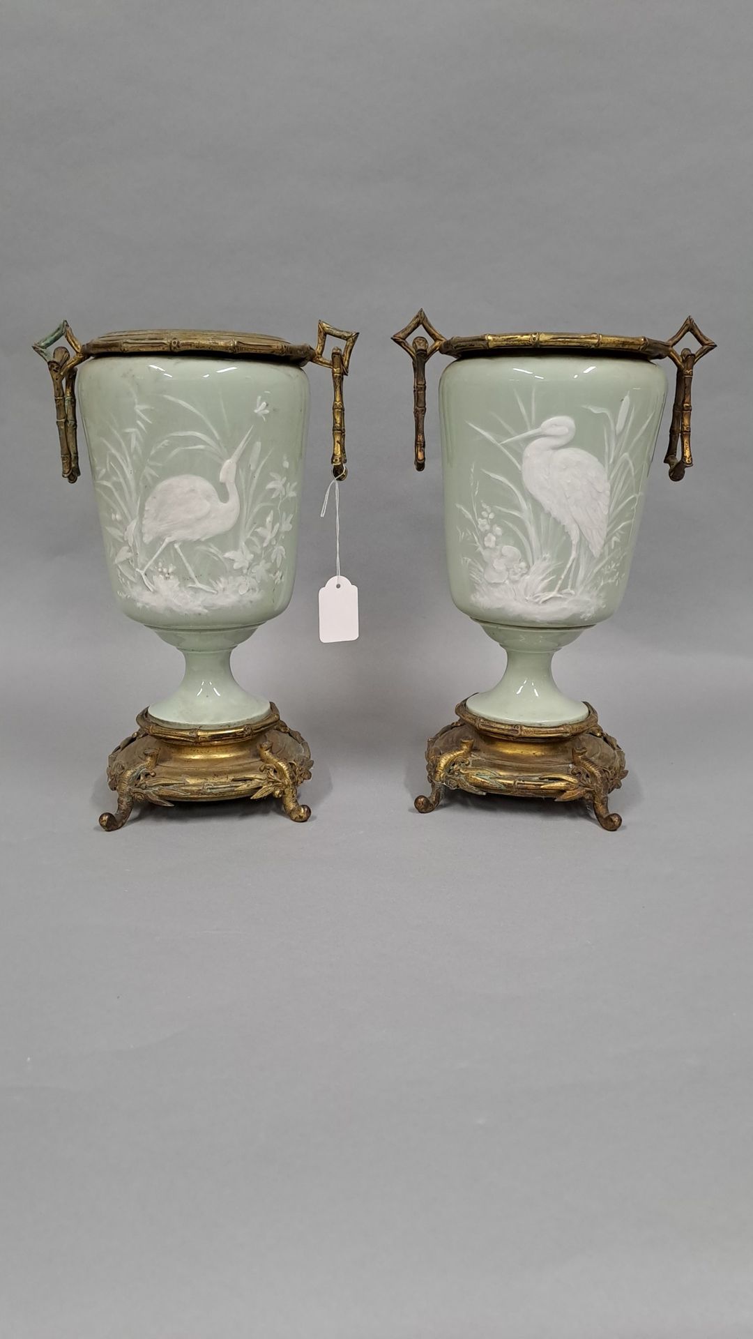 Null 一对青瓷花瓶，白色浮雕的涉水者，铜质底座和竹子装饰的支架。19世纪晚期。



高度：31厘米。