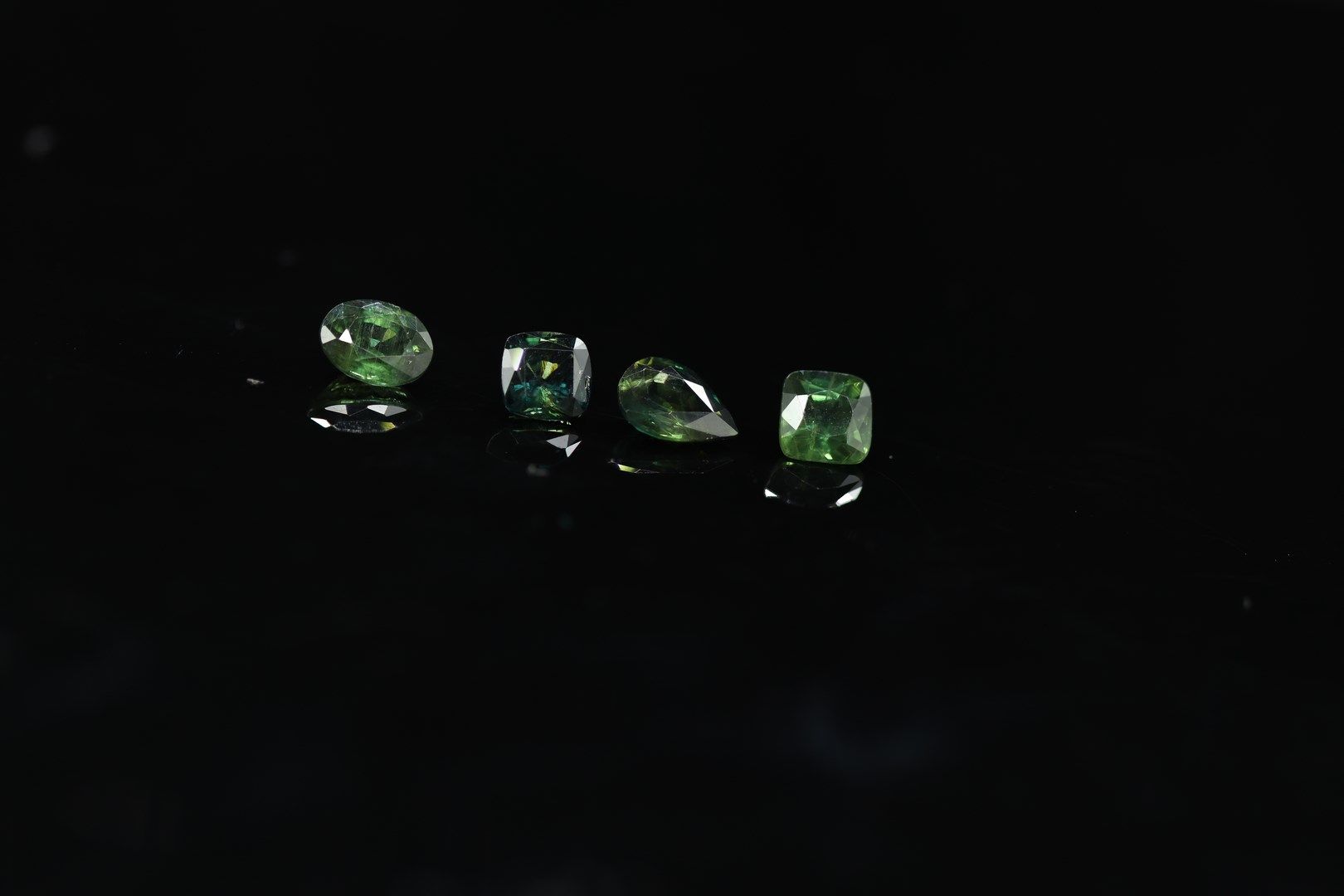 Null Lot of four bluish green sapphires of mixed size on paper. 

Total weight :&hellip;