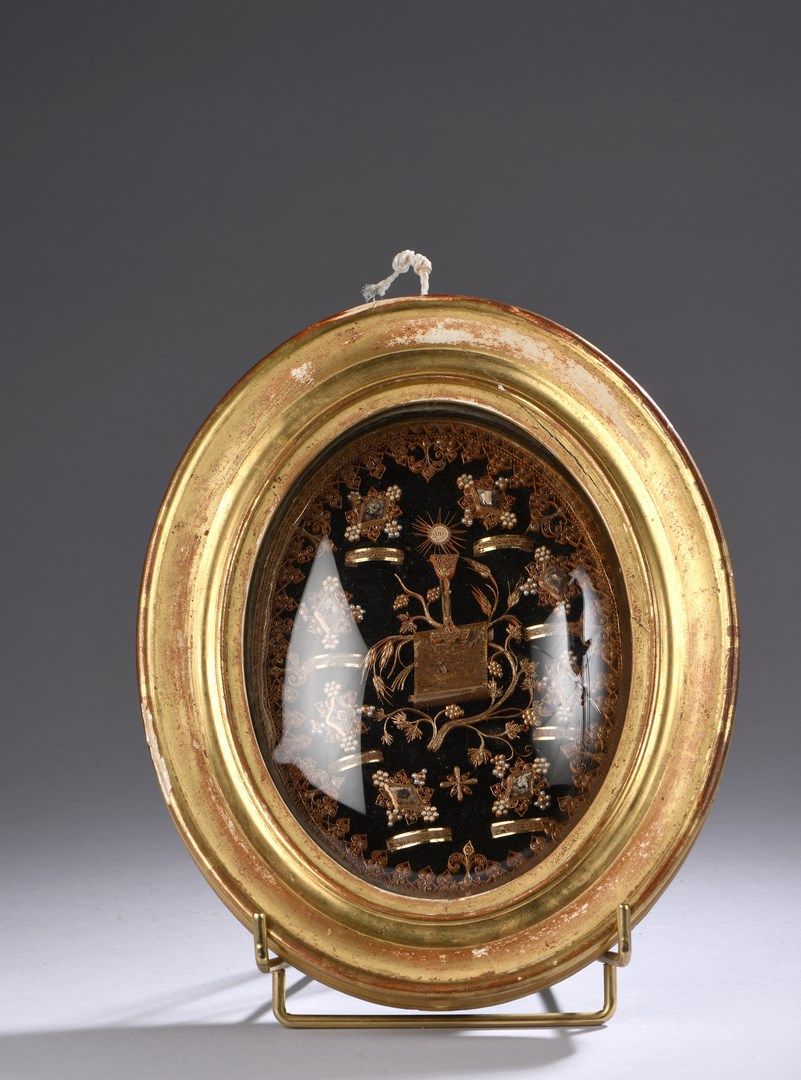 Null Quadro reliquiario di forma ovale con carta policroma e dorata. Decorato al&hellip;