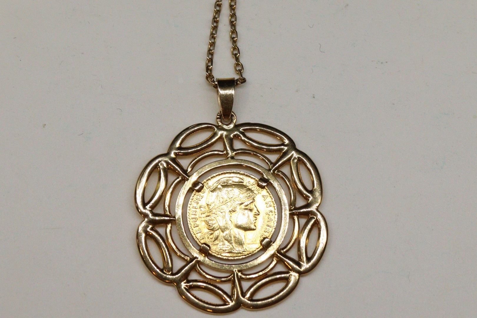 Null 20法郎的公鸡金币（1907年）在18K（750）黄金纪念章及其18K（750）黄金链。

标有一个鹰头。

重量：26.28克。: 26.28g