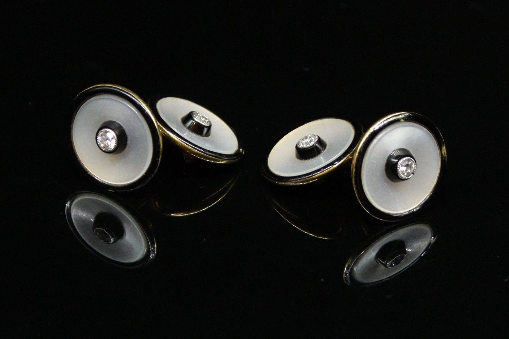 Null 一对18K(750)黄金袖扣，每个袖扣都有一颗钻石和一个黑色珐琅彩的珍珠母盘。

毛重：5.93克

(缺失)