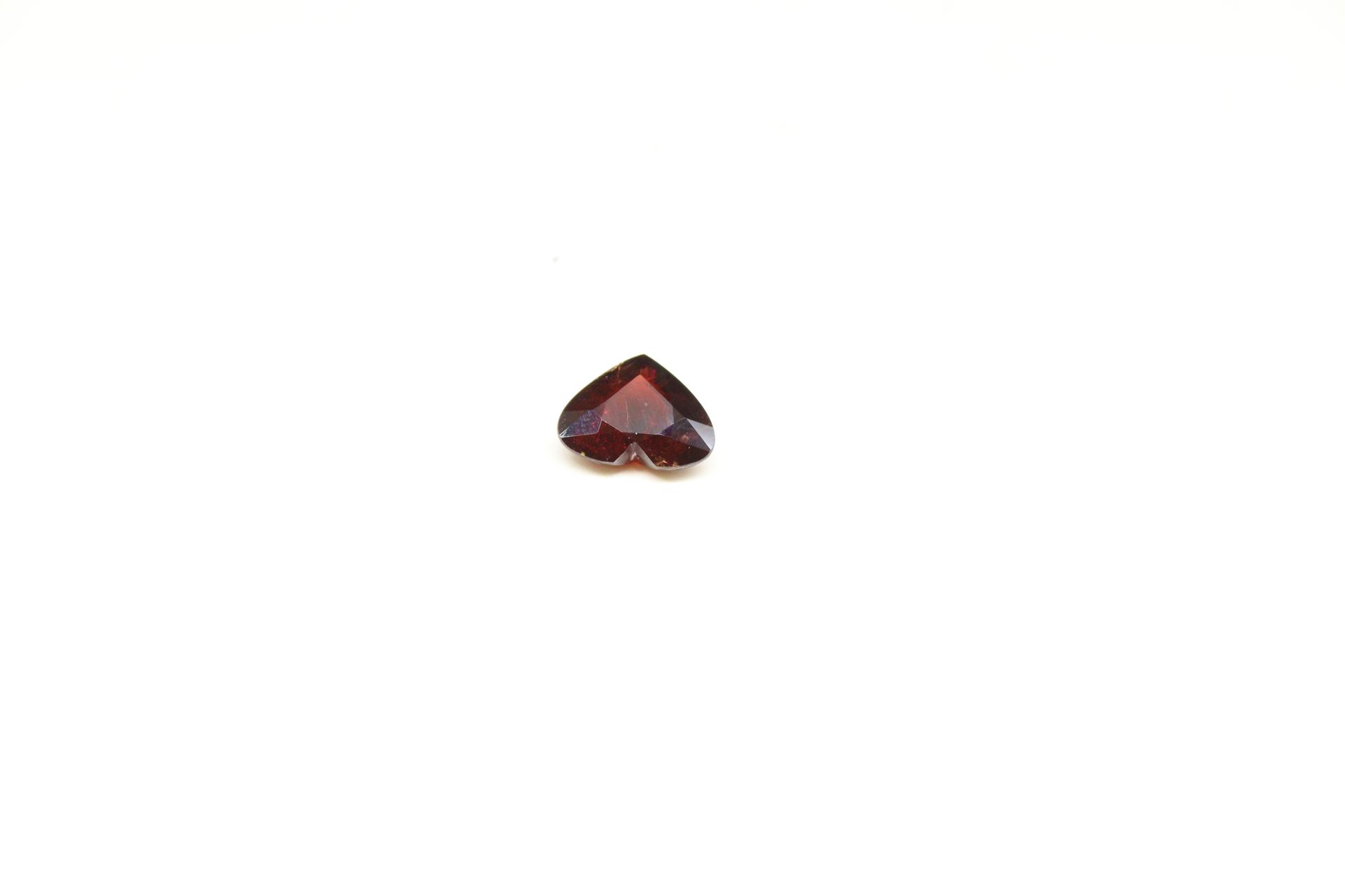 Null Garnet heart on paper. 

Weight : 8.02 cts.

(chips, shocks)