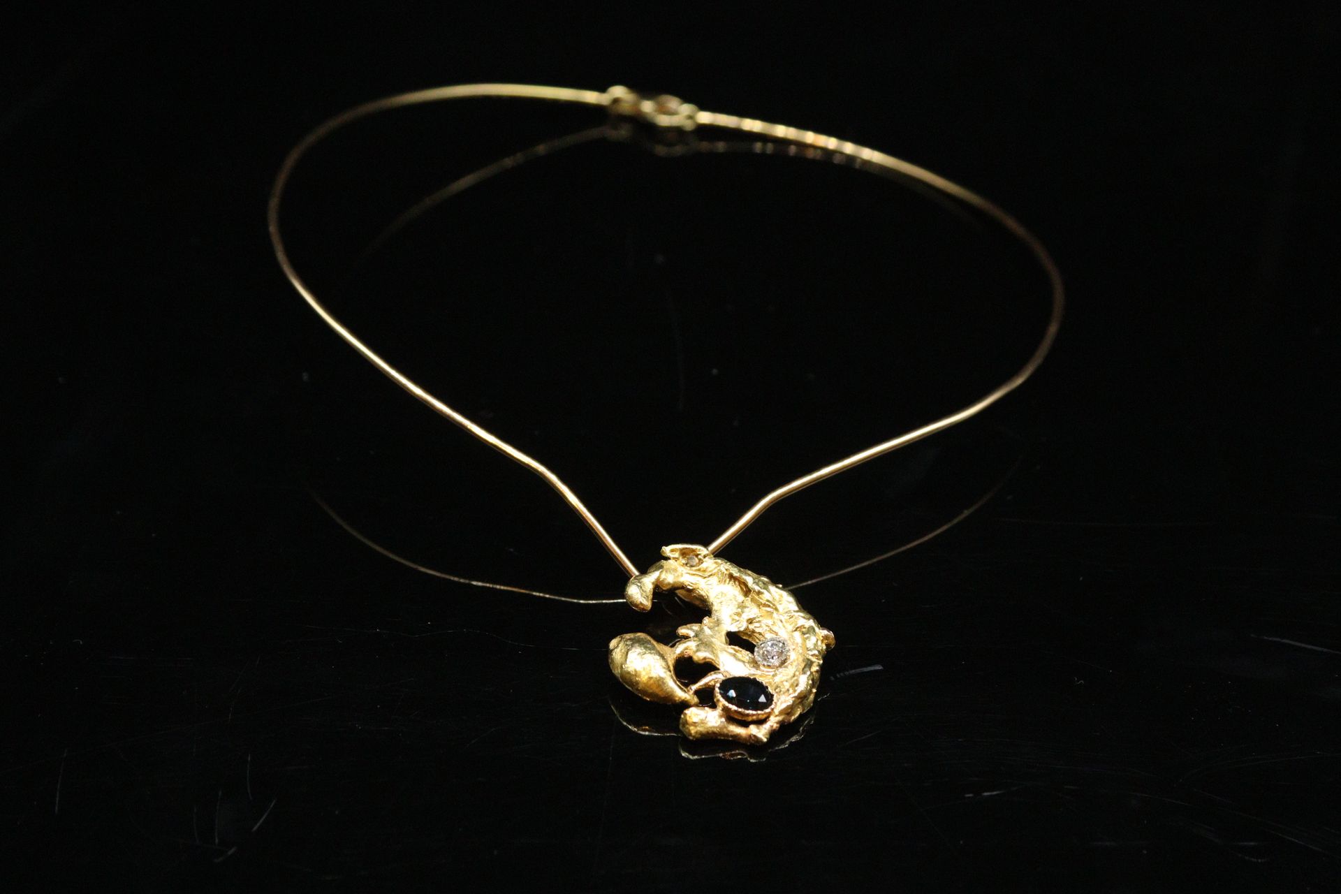 Null 
18K（750）黄金项链，加工过的黄金金块吊坠上镶嵌着一颗椭圆形蓝宝石和一颗圆形钻石。 




脖子周围的直径：约12厘米 - 毛重：25.51克&hellip;