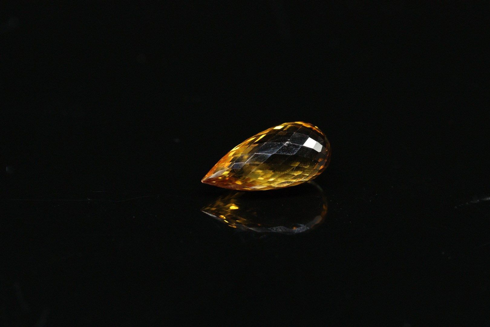Null Citrine briolette on paper. 

Weight : 13.23 cts.