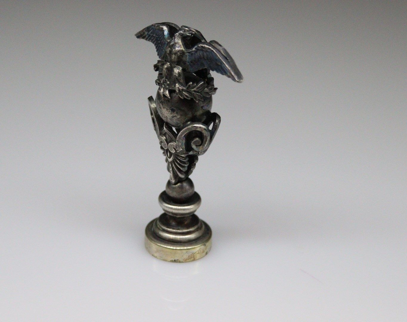 Null 镀银金属印章，双面握把显示的是张开翅膀的帝王之鹰，爪子里抓着朱庇特的纺锤，闪闪发光。圆形钢模上刻有MG。
高度：6.60厘米。
