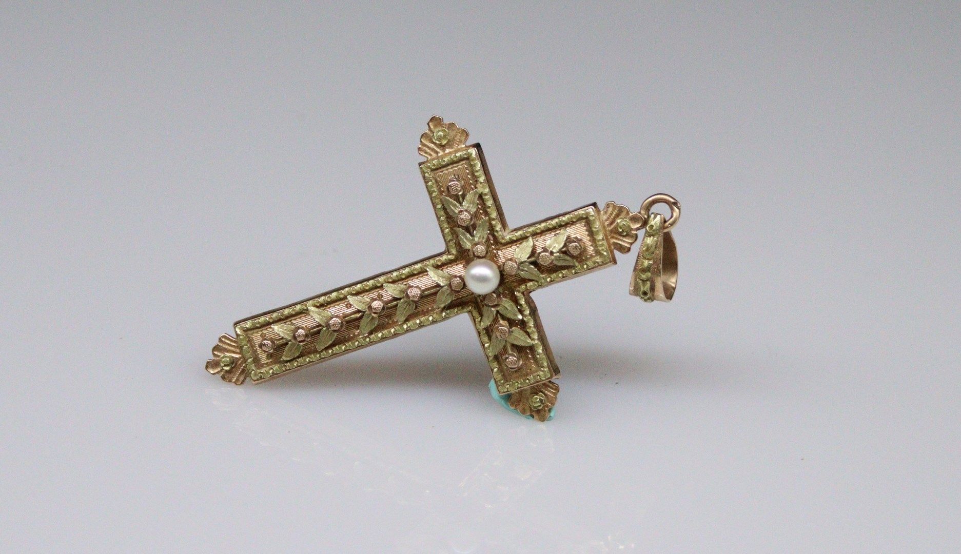 Null 一件18K（750）黄金和玫瑰金十字架吊坠，上面有一颗珍珠和一片叶子的设计。 
法国的工作。 
高度：6.5厘米。- 毛重：6.65克。