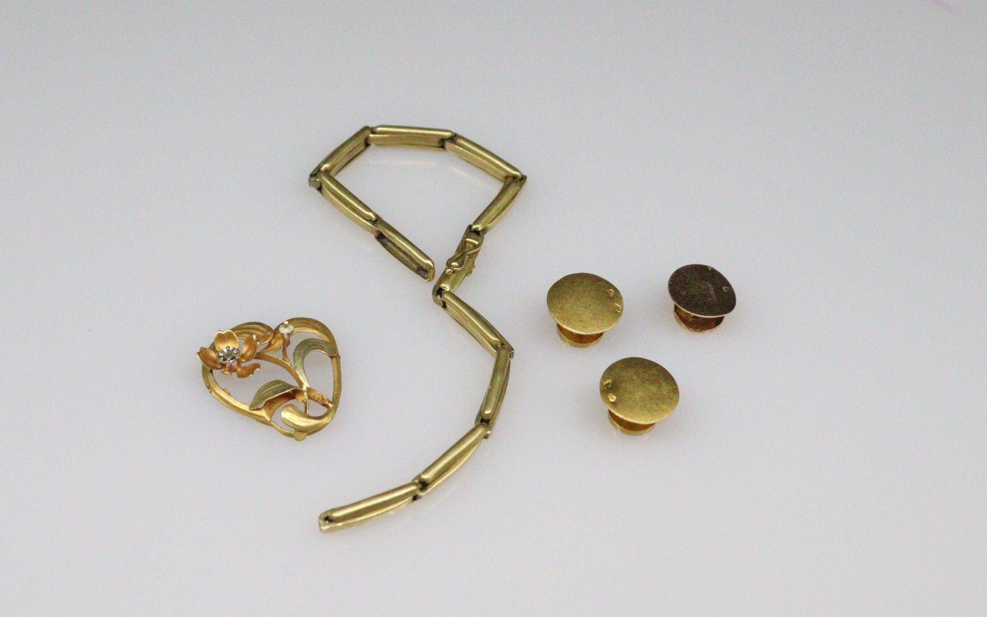 Null 一批18K（750）黄金碎片包括: 
-三个领扣 
- 废旧手镯 
- 白石胸针
重量：7.3克。