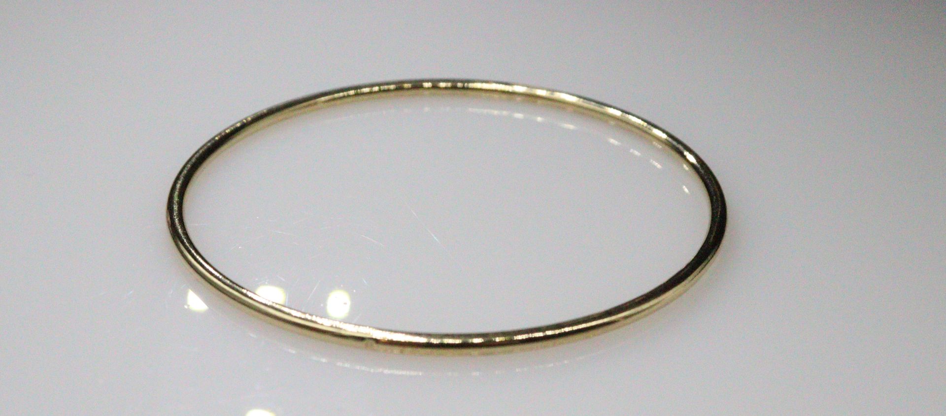 Null Armreif aus vergoldetem Metall.
Durchmesser: ca. 65 cm
