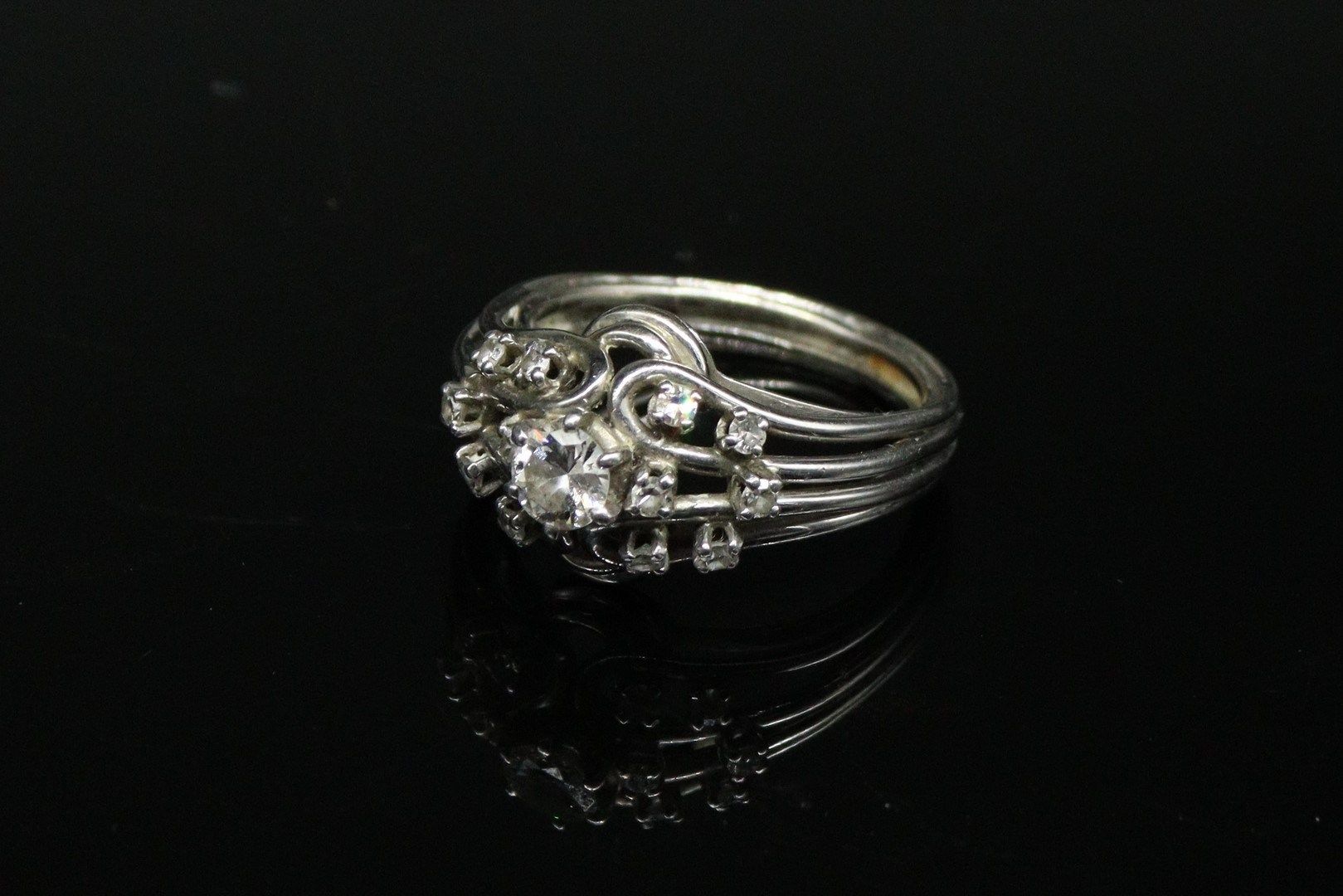 Null 18K（750）白金和铂金戒指，镶嵌着一颗钻石，周围有12颗钻石。
标有一个鹰头。
手指大小：59 - 毛重：7.35g