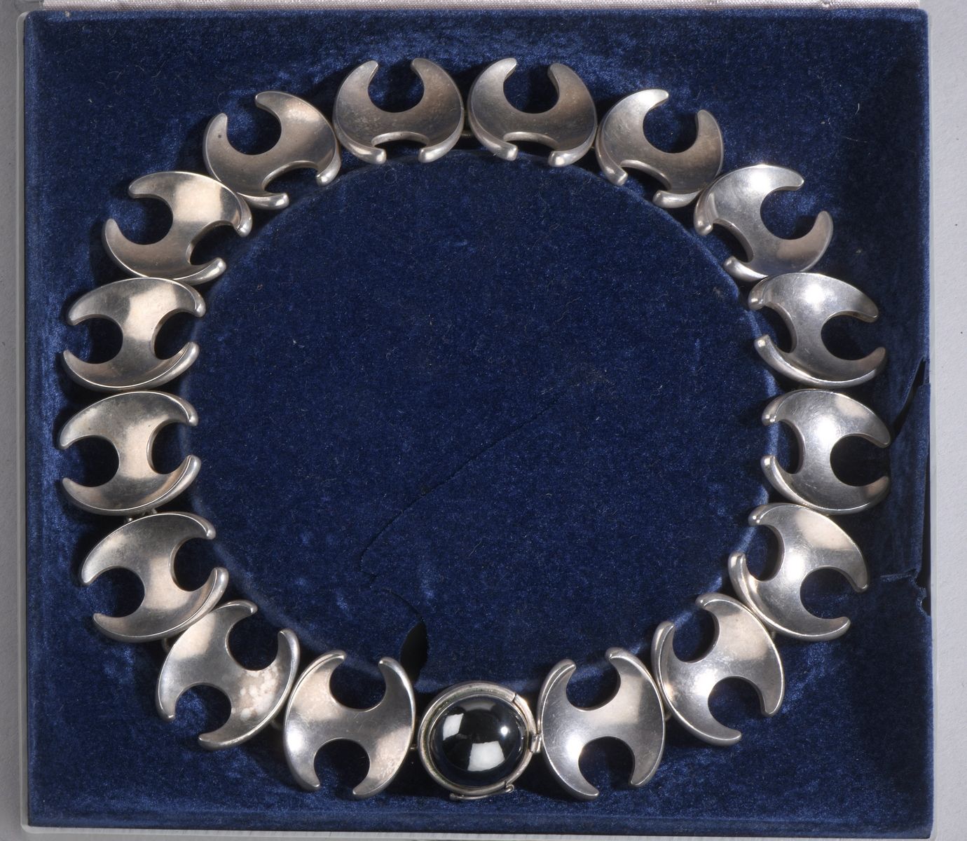 Null 亨宁-科佩尔的乔治-延森作品
银制（925）项链 "130 B"，链节组成 "H"。扣子上镶嵌着一颗大的凸圆形血红石。
长41厘米 - 毛重：141.&hellip;