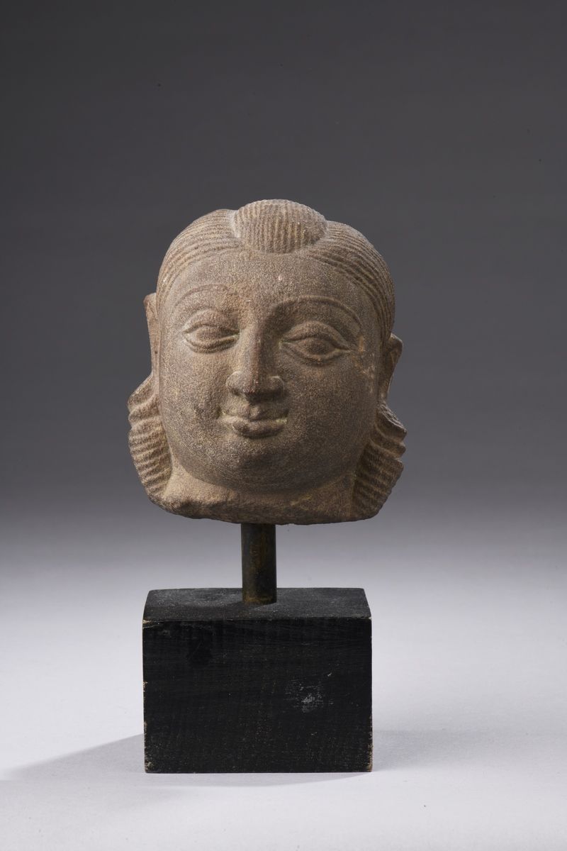 Null 印度 - 中世纪时期，12/13世纪
粉红砂岩的女性头像，头发被细细地凿过，耳朵上有大的挂件装饰。 
H.11厘米