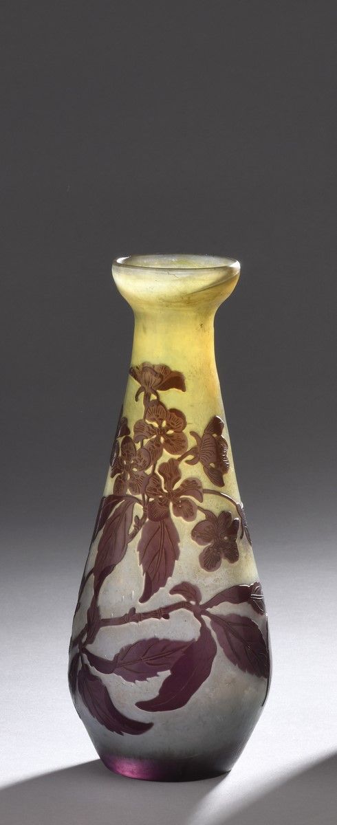 Null 加勒公司 
圆锥形花瓶，敞开颈部。紫罗兰色的玻璃证明，白色的黄色背景。苹果花的装饰是用酸液浮雕的（在颈部有两个气泡延伸）。
已签名。
高20厘米
如目&hellip;