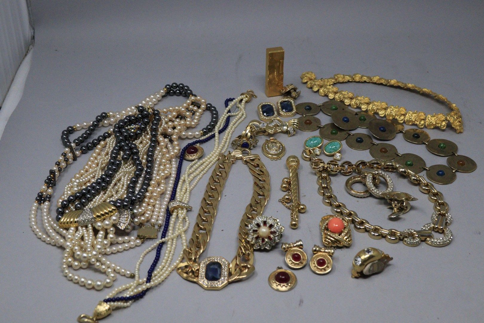 Null 大量的服装珠宝，包括: 
- 5条珍珠项链
- 4条金项链
- 11个耳夹
- 2个珠宝扣子
- 2个吊坠 
- 一个蜂鸟打火机
- 一个胸针