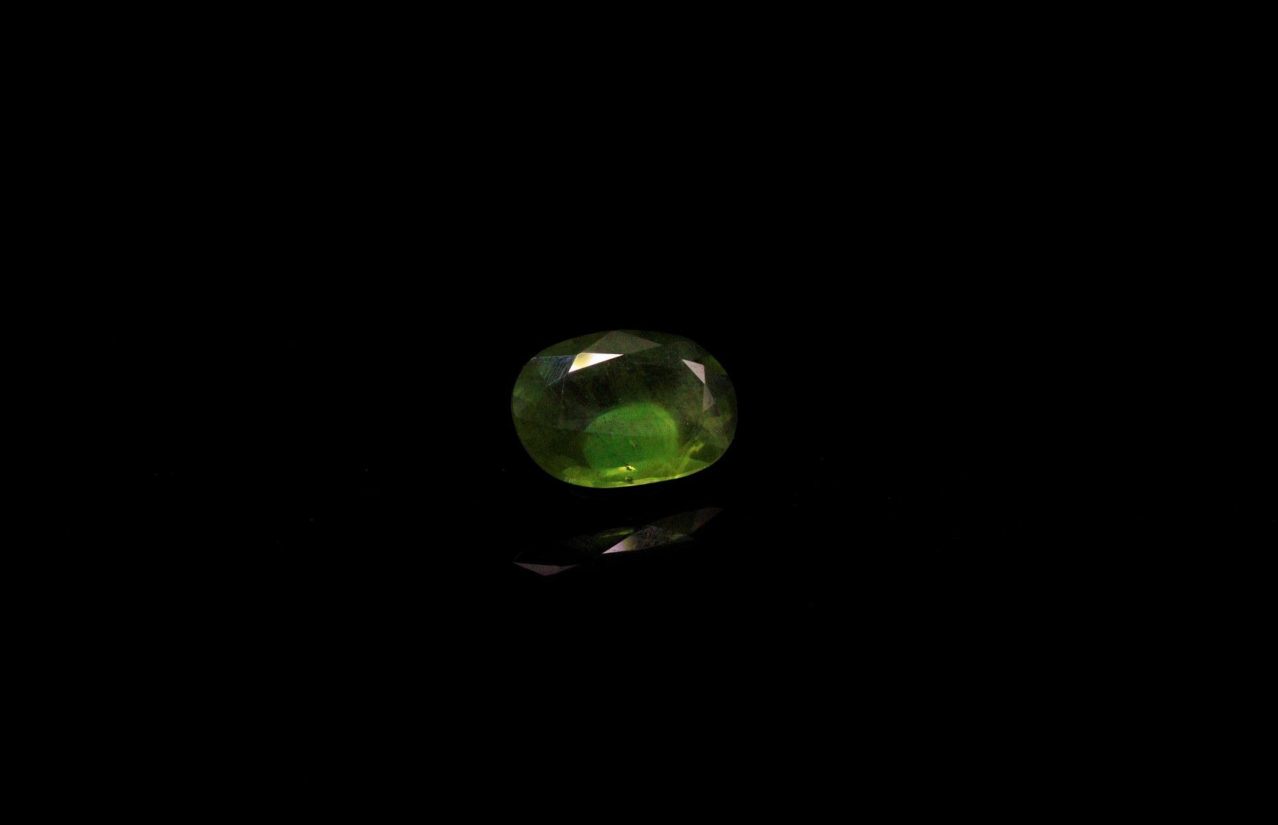 Null 椭圆形的绿色蓝宝石在纸上。 
重量 : 1.69克拉。 
尺寸 : 9.6毫米 x 5.2毫米