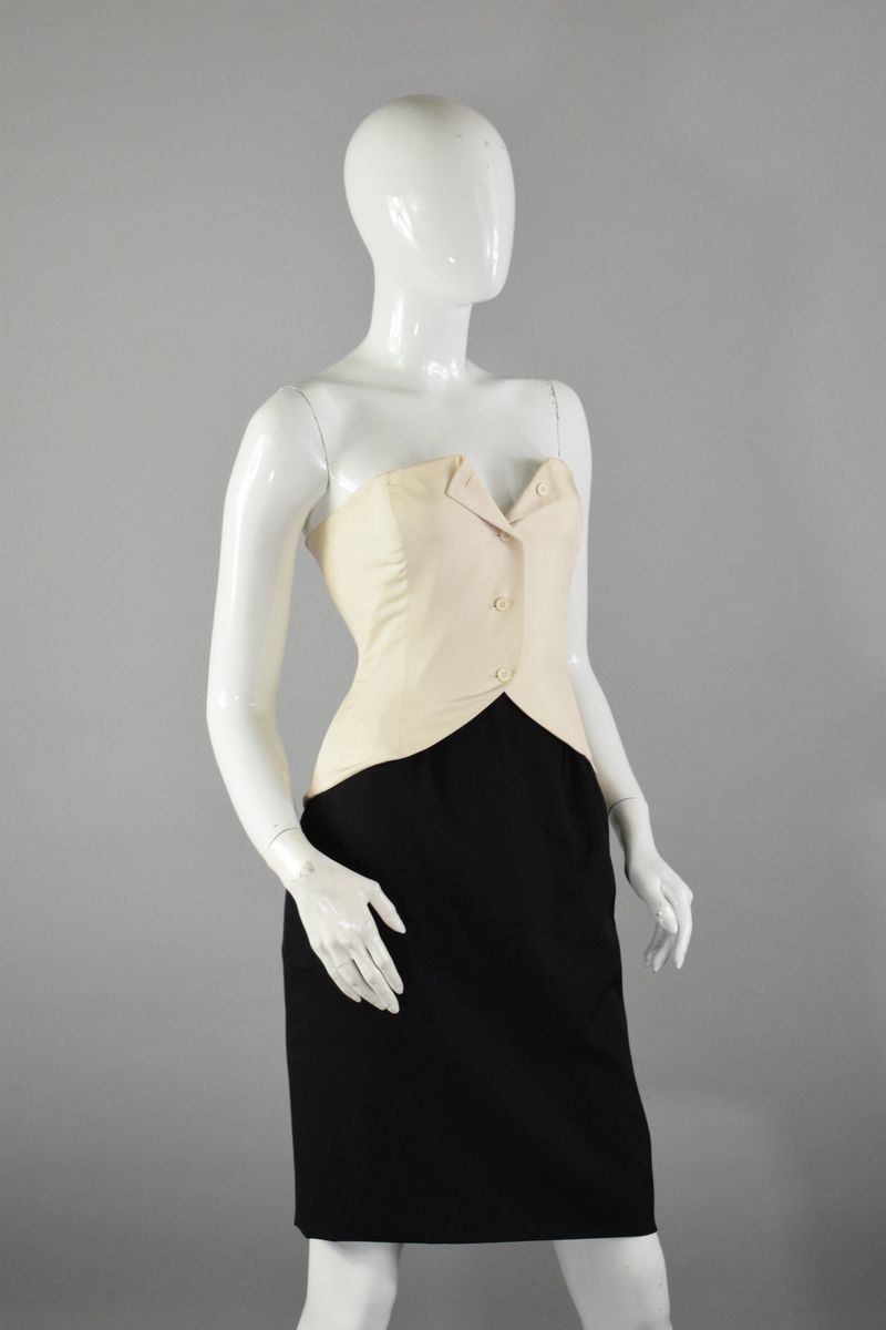 Null 克里斯蒂安-迪奥专卖店
约1990年

白色野丝胸衣，前面有配套的纽扣，后面有漂亮的黑色蝴蝶结。 
非常轻微的磨损。 

尺寸：38/40左右。