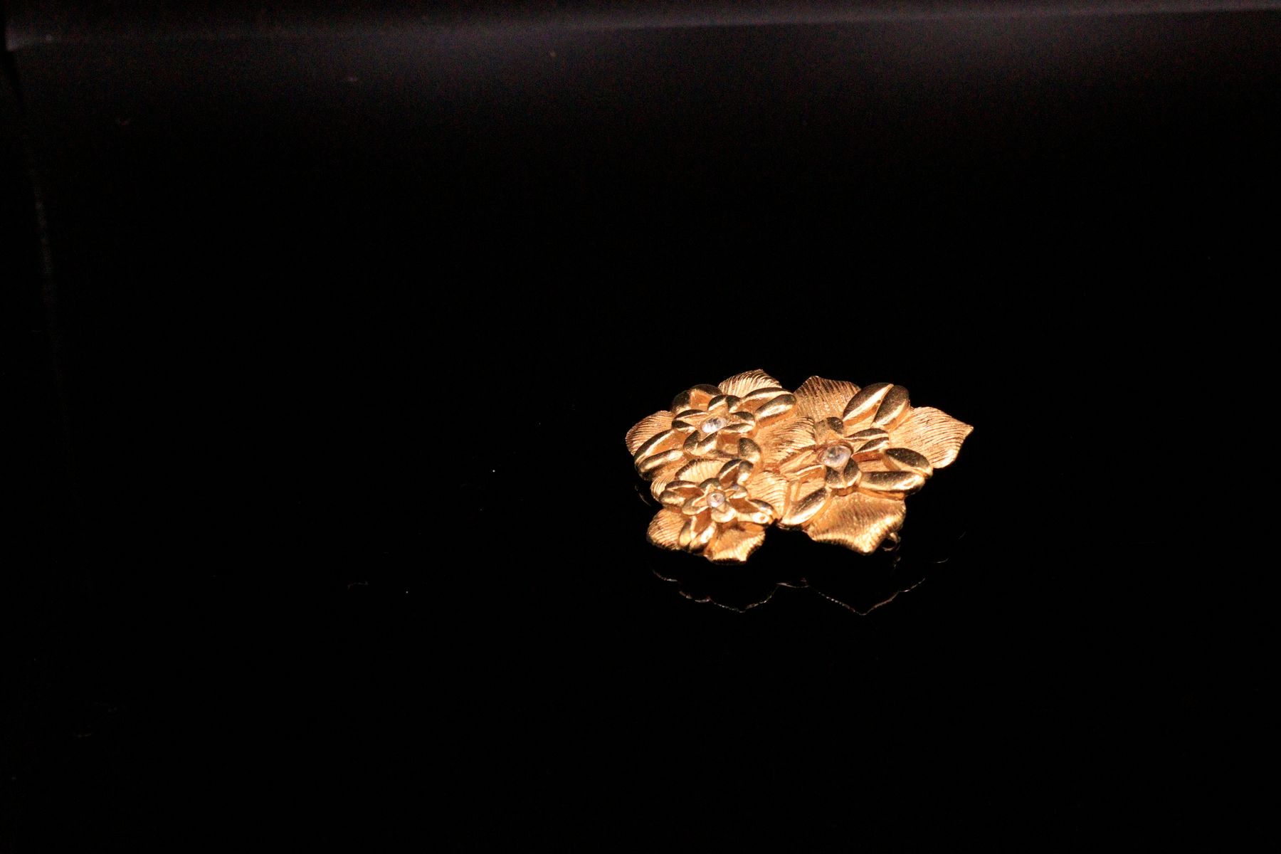 Null LORIS AZZARO

镀金金属胸针，有三朵以水钻为中心的风格化花朵。 

高度：4厘米