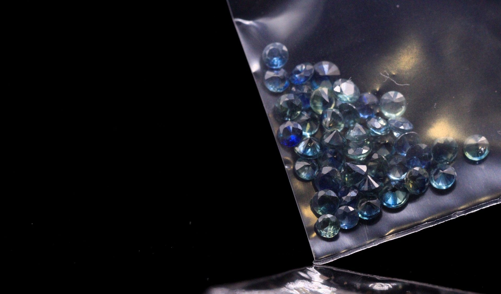 Null 四十颗圆形蓝宝石的混合体在纸上。 
总重量：3.41克拉。 

直径：从2.2毫米到2.7毫米