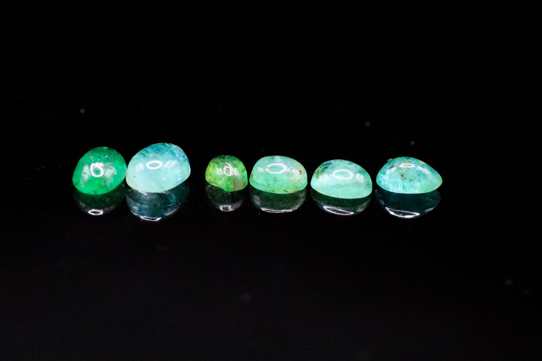 Null Mixture of six oval cabochon emeralds on paper.
Weight: 1.64 ct