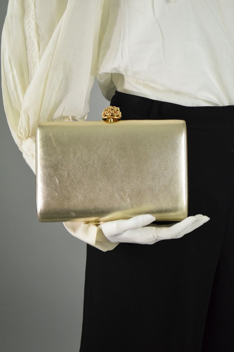 Null 弗兰科-贝利尼

镀金皮革包覆迷你皮包，饰以镀金金属珍珠纽扣。 
可拆卸肩带，缎面内衬。 

尺寸：15 x 21 x 5 厘米