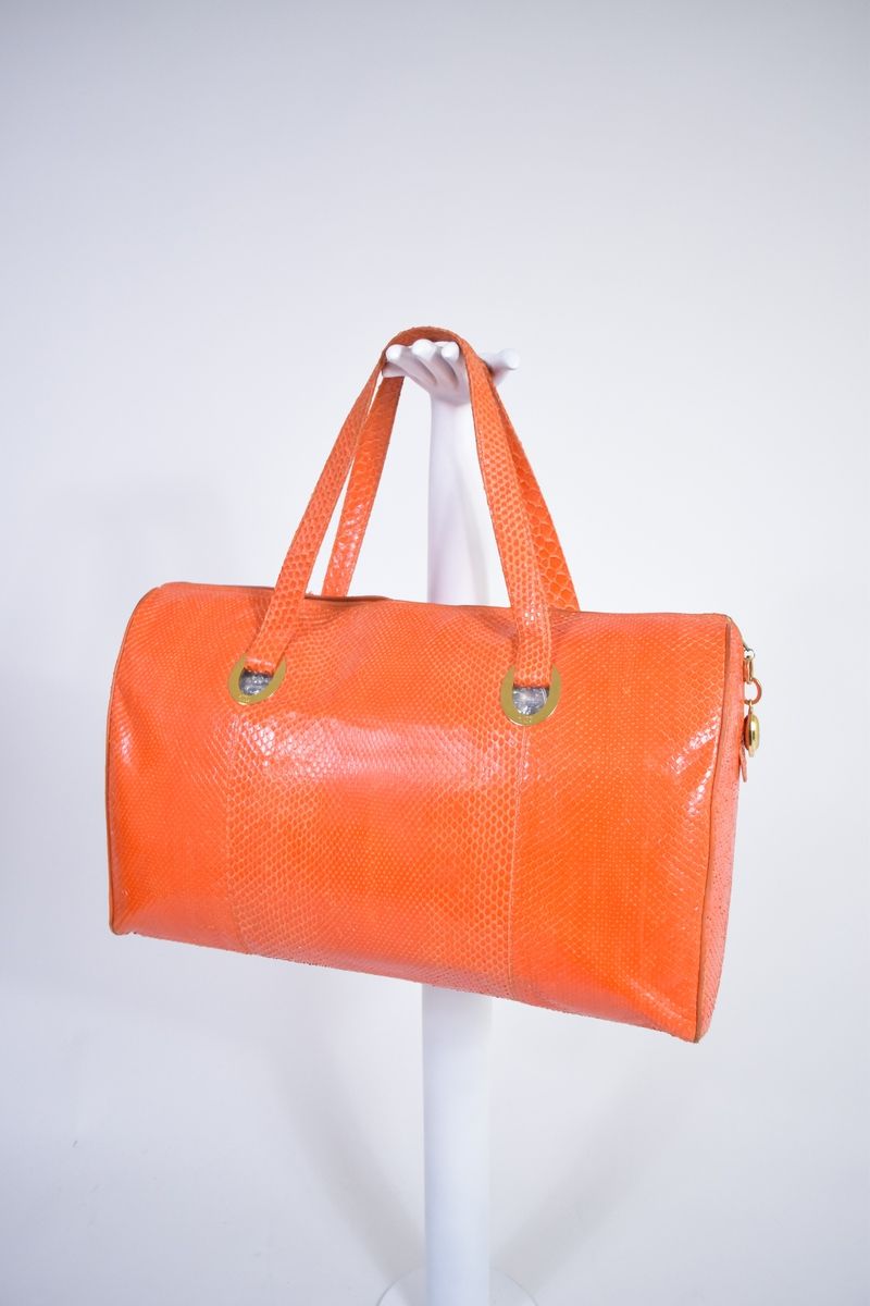 Null 克里斯汀-迪奥精品店 
约1985年

罕见的火橙色蟒蛇皮波士顿包，平手柄可手提或肩背。 
全长拉链，金色金属徽章饰品。 
略有磨损。 

尺寸：50&hellip;