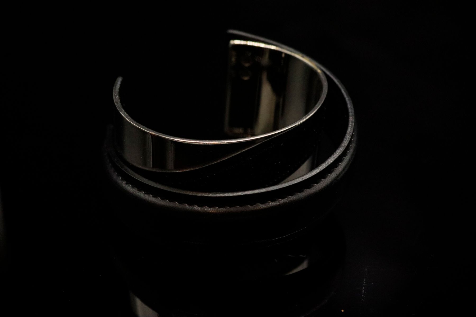 Null 巴黎 HERMES 
约 2000 年底

罕见的不对称手镯，饰以硬质黑色皮质表带。 

最宽处直径：6.5 毫米 

附带包装盒。