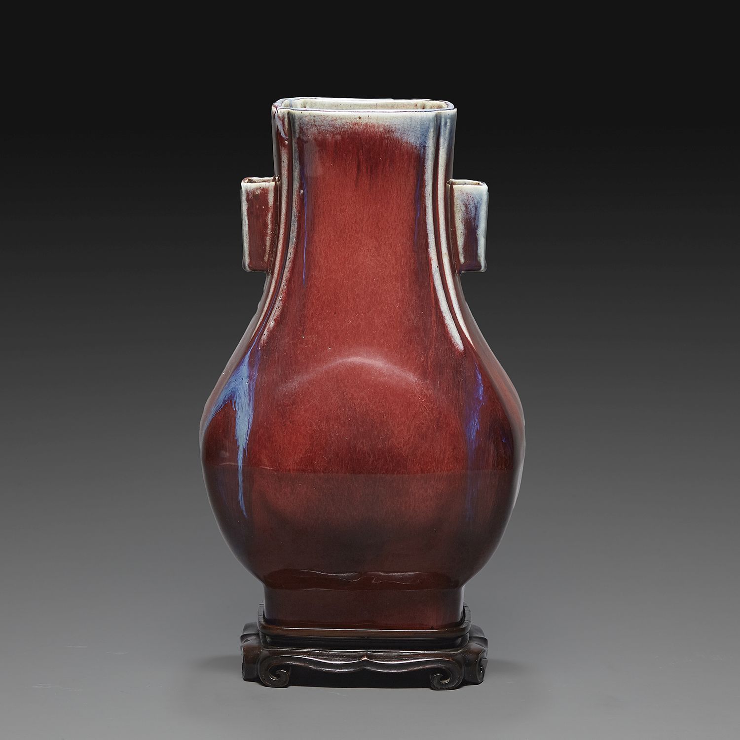 Null ZUN花瓶，有两个把手
瓷器和火焰珐琅的牛血色，深紫色和棕色的颜色。底部刻有开州风格的 "大清乾隆年制 "六字款。有一个木质底座。
中国，20世纪初。&hellip;