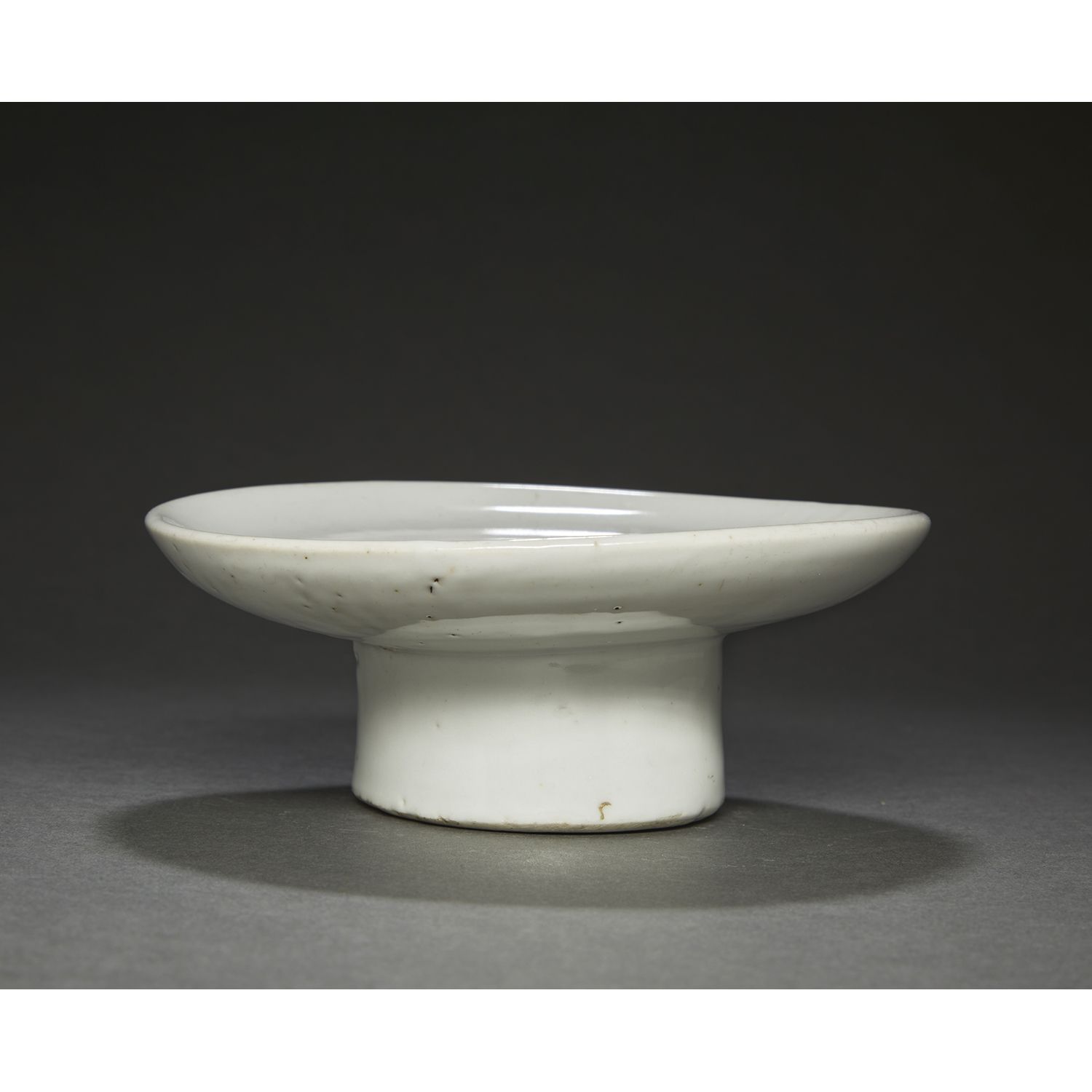 Null 
，白釉瓷器，由高跟鞋上的圆形托盘组成。
 （釉面有小裂纹，边缘有小缺口，划痕，烧制缺陷）。
韩国，朝鲜时期，18世纪末。
高脚白釉供盘，韩国，18世&hellip;