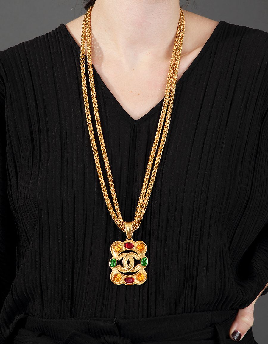 CHANEL, Long necklace with double chain in gilded metal and pendant of  four-lobed shape with eight cabochons in cast glass of green, red and  yellow Double C central of the House of