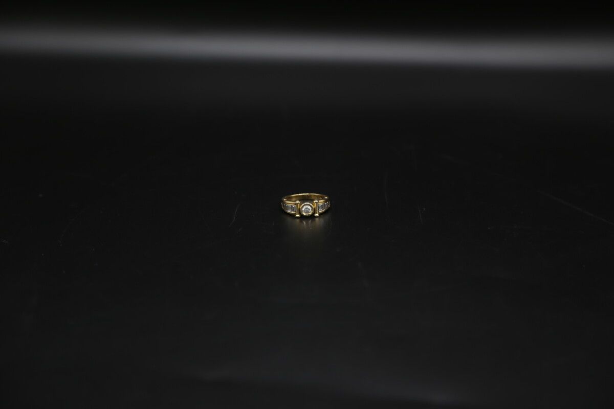 Null Bague en or jaune (750) orné d'un diamant central rond brillant d'environ 0&hellip;