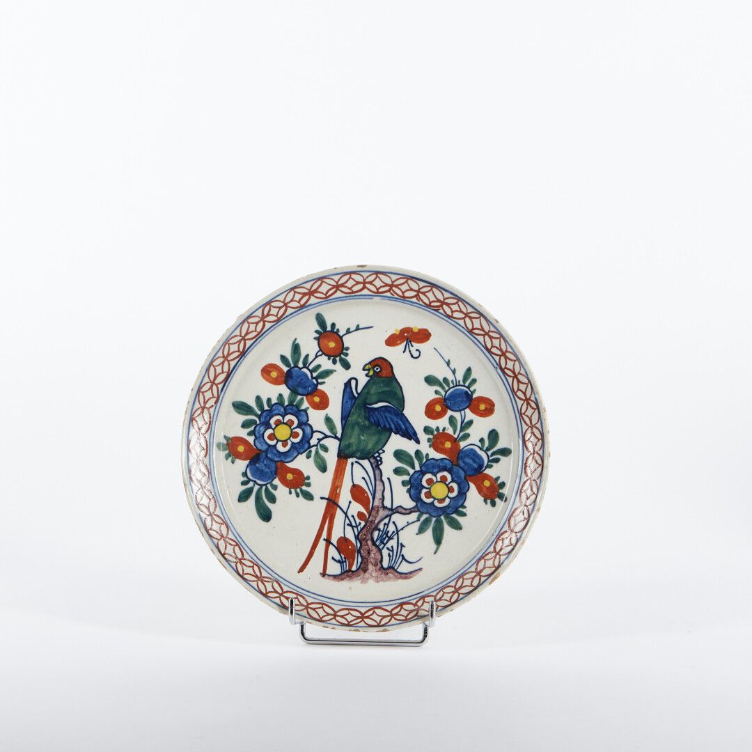 Null 德尔福

陶器盘，形状为pannekoek，有鹦鹉和花枝的多色装饰，有格子边。

18世纪。

直径：22.5厘米。