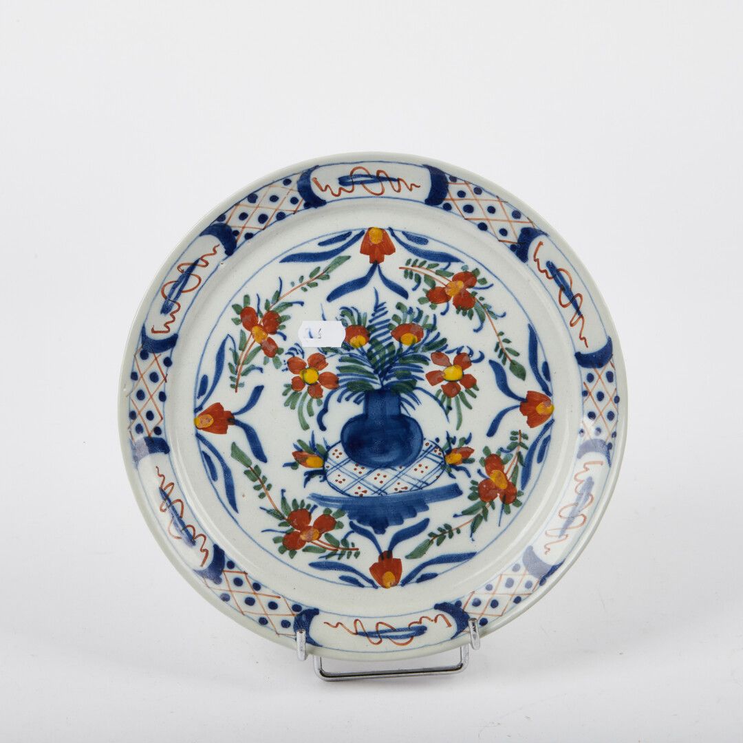 Null 德尔福

陶器pannekoek盘，中间有花瓶的多色装饰，花和十字架。

18世纪。

直径：23厘米。