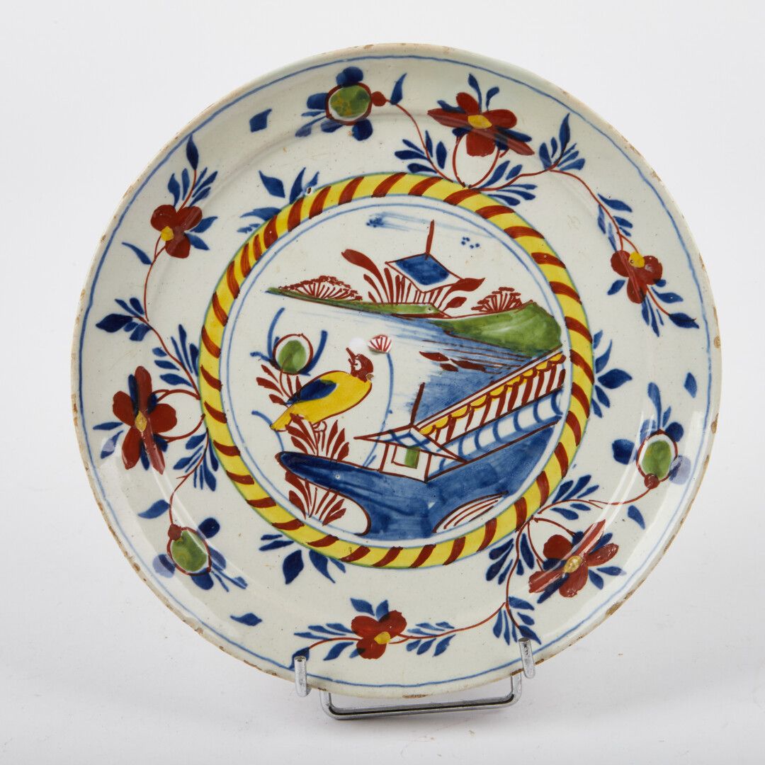 Null 德尔福

Pannekoek盘子，有鸟、障碍物和风格化的宝塔等多色装饰。

18世纪。

直径：22厘米。

(在边缘进行修复)
